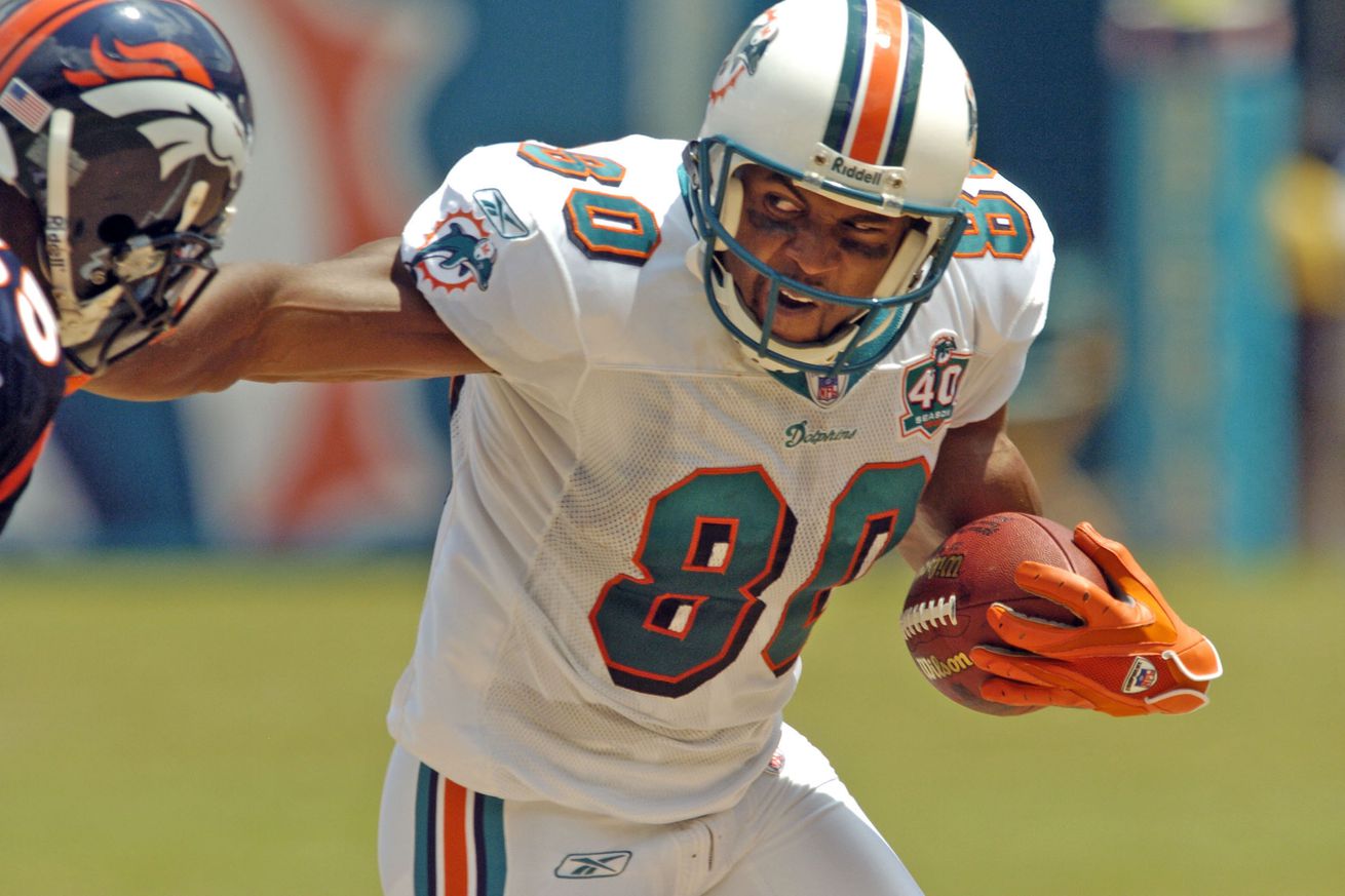 MIAMI, FLORIDA, SEPTEMBER 11, 2005 - Miami Dolphin #80 David Boston stiff arms #65 Bronco Cooper Carlisle during the game between the Denver Broncos and the Miami Dolphins at Dolphins Stadium in Miami on Sunday September 11, 2005. (DENVER POST PHOTO BY HY